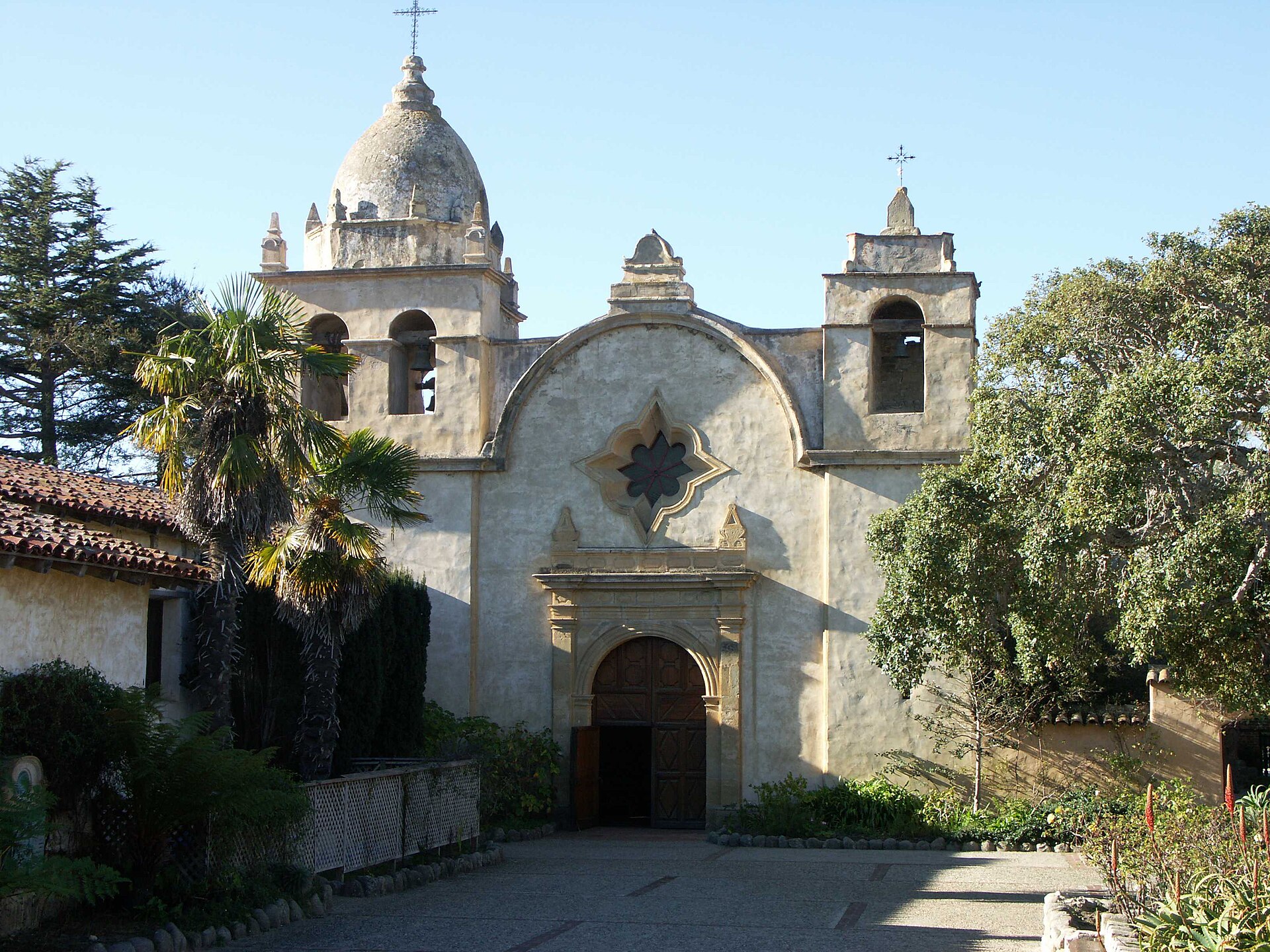 The stone facade and bell tower of Mission San Carlos Borromeo de Carmelo