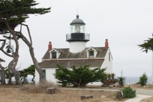 The Point Pinos Lighthouse at the tip of the Monterey Peninsula, its stone tower rising above coastal scrub.